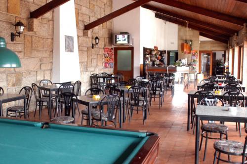 un ristorante con tavolo da biliardo, tavoli e sedie di Parque de Campismo Orbitur Angeiras a Angeiras