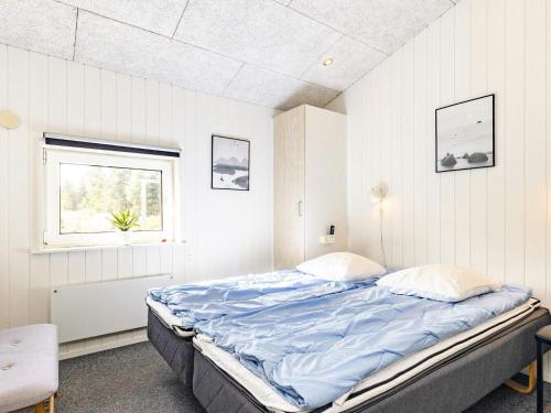 ブラーバンドにあるFive-Bedroom Holiday home in Blåvand 18の窓付きの白い部屋の大型ベッド1台