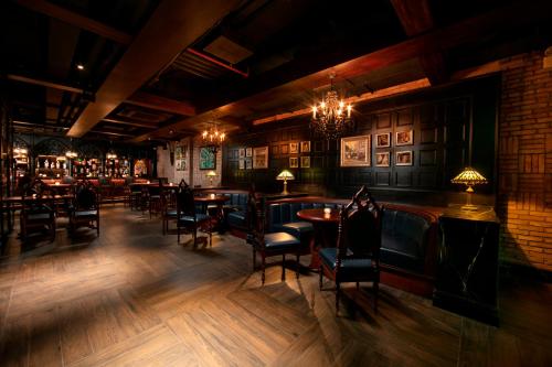 - un bar avec des tables et des chaises dans une pièce dans l'établissement Le Chanvre Hanoi Hotel & Spa, à Hanoï