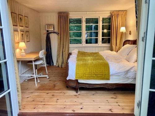 een slaapkamer met een bed, een bureau en een raam bij Holiday home Hornbæk II in Hornbæk
