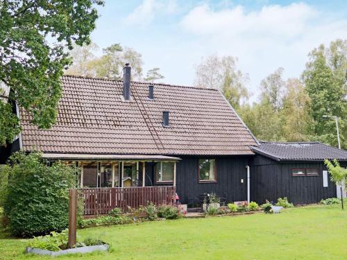 a black house with a brown roof at 4 star holiday home in ULLARED-By Traum in Ullared