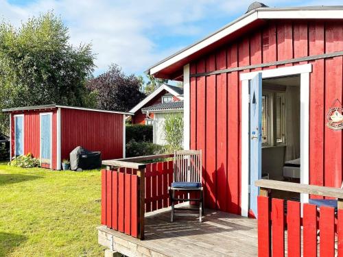 a red shed with a chair on a deck at 4 star holiday home in SÖLVESBORG-By Traum in Sölvesborg