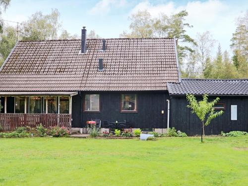 a black house with a large yard in front of it at 4 star holiday home in ULLARED-By Traum in Ullared