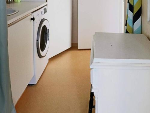 a kitchen with a washer and a white refrigerator at 4 star holiday home in VARBERG-By Traum in Varberg