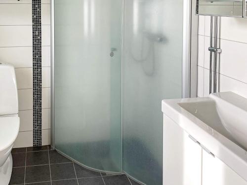 een badkamer met een glazen douche en een wastafel bij Holiday home SÖLVESBORG XIII in Sölvesborg