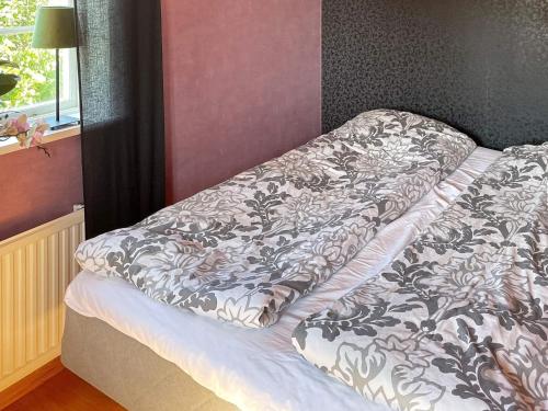 - un lit avec une couette dans une chambre dans l'établissement Holiday home SÖLVESBORG XII, à Sölvesborg