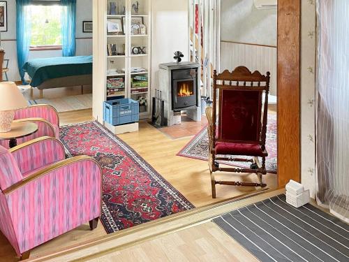 uma sala de estar com lareira e um sofá e cadeiras em Holiday home RONNEBY XI em Ronneby
