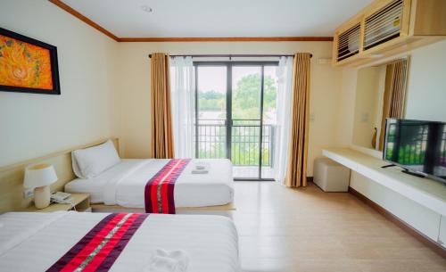 a hotel room with two beds and a television at Tayama Farm Khaoyai in Nakhon Ratchasima