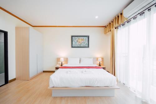 a white bedroom with a bed and a tv at Tayama Farm Khaoyai in Nakhon Ratchasima