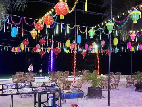 a party with lanterns and tables and chairs at Green Ocean Lodge in Koh Rong Island