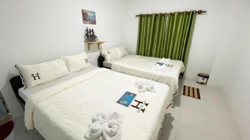 ロン島にあるGreen Ocean Lodgeのベッド2台 緑のカーテン付きの部屋