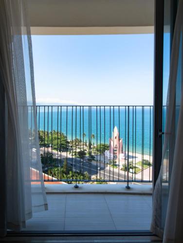 a room with a view of the ocean from a balcony at PANORAMA Condotel by HLG in Nha Trang
