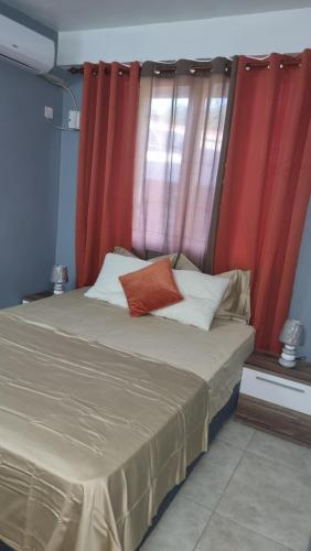 1 cama con almohadas de color naranja y blanco en una habitación en Homely Escapes by Pulse en Loubiere