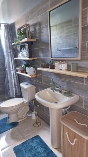 a bathroom with a toilet and a sink at Homely Escapes by Pulse in Loubiere