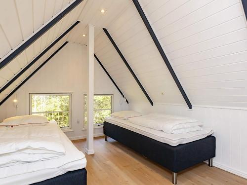ブラーバンドにあるFour-Bedroom Holiday home in Blåvand 39の白い壁の屋根裏部屋のベッドルームにベッド2台
