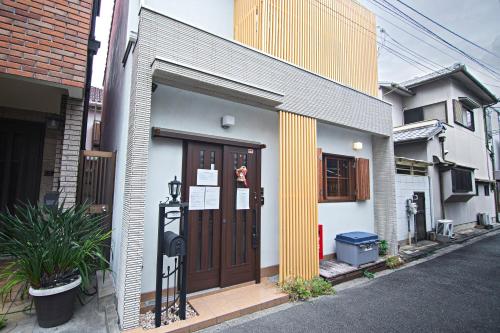 a building with a wooden door on a street at -粉浜飛鳥- 和風ヴィラ 玉出駅 in Osaka