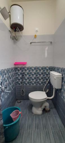 a bathroom with a toilet and a bucket at Teja Residency in Alāndurai