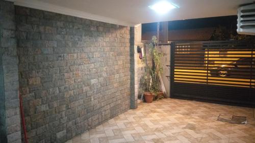 Cette chambre est dotée d'un mur en briques et d'une porte noire. dans l'établissement Casa 1 Encanto dos Mares, à Itapema