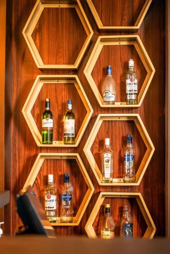 a wooden honeycomb wall with bottles of whiskey at The Pharo in Nittambuwa