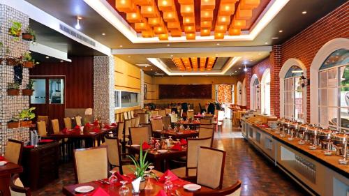 The Pharo في Nittambuwa: غرفة طعام مع طاولات وكراسي في مطعم