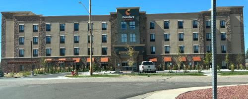 a large building with a van parked in front of it at Comfort Suites Cheyenne in Cheyenne