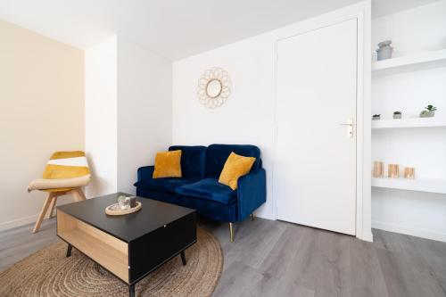un salon avec un canapé bleu et une table dans l'établissement T2 idéal déplacement pro, entièrement rénové, à Rouen