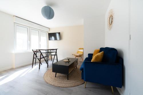 un salon avec un canapé bleu et une table dans l'établissement T2 idéal déplacement pro, entièrement rénové, à Rouen