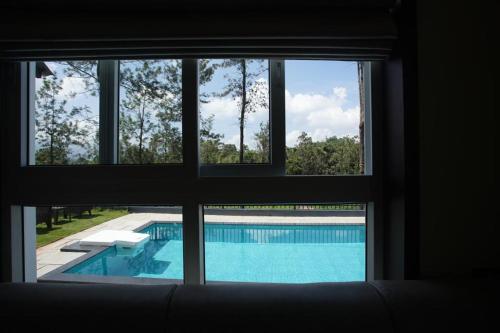 a view of a swimming pool through a window at Pabis luxurious stay in Vythiri