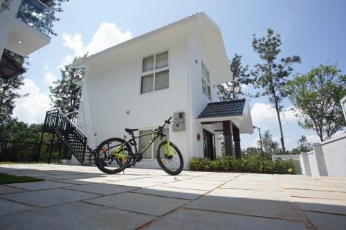 a bike parked in front of a white house at Pabis luxurious stay in Vythiri