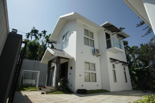 a white house with a lot of windows at Pabis luxurious stay in Vythiri