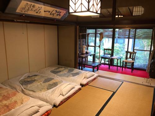 pokój z łóżkiem w rogu pokoju w obiekcie Kappo Ryokan Uoichi w mieście Shimada