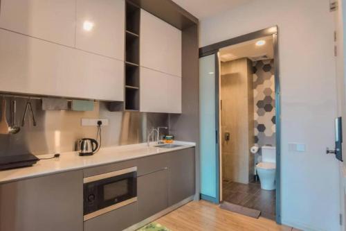 cocina con armarios blancos y aseo en una habitación en Ceylonz Suites Bukit Bintang by KL ONE, en Kuala Lumpur