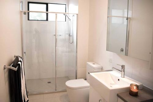uma casa de banho com um chuveiro, um WC e um lavatório. em "Palm Retreat" - Private, Spacious and Bright em Noosa Heads
