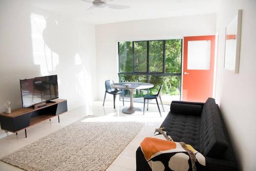 uma sala de estar com um sofá e uma mesa em "Palm Retreat" - Private, Spacious and Bright em Noosa Heads