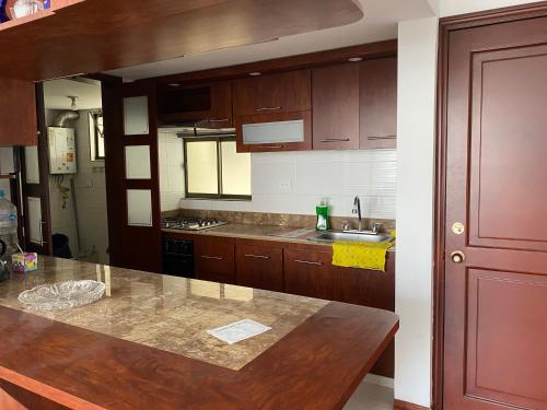 a kitchen with wooden cabinets and a counter top at JARDIN DEL ATRIZ in Pasto