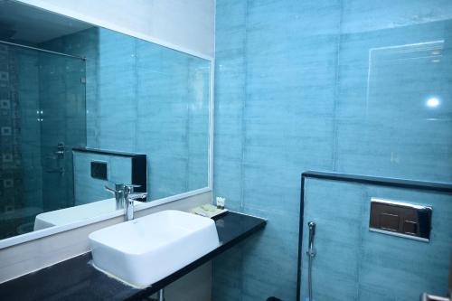 a bathroom with a white sink and a mirror at Pipul Ocean View Resort in Puri