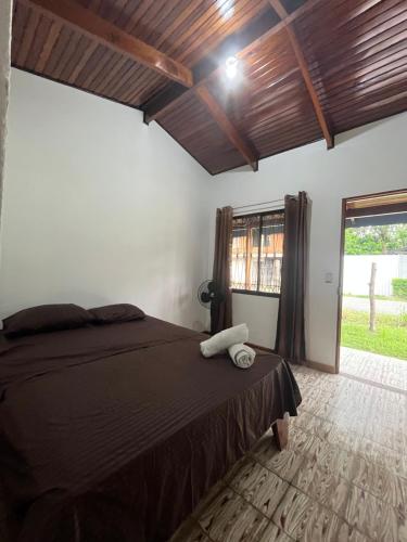 a bedroom with a bed and a large window at #3 Cabina Rústica para 2 personas en Paquera in Paquera