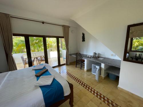 a bedroom with a bed and a desk in a room at Kep Lodge in Kep