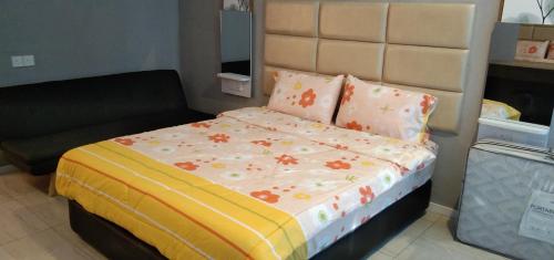a bedroom with a bed with flowers on it at PINTARMAN SERVICE APRTMENT @ THE STIRLING SUITES in Miri