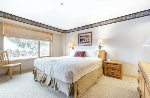 a bedroom with a large bed and a window at Shoshone by DC in Big Sky