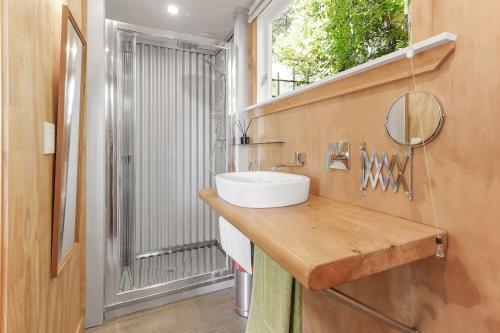 a bathroom with a sink and a window at The Treehouse - Raglan Holiday Studio in Raglan