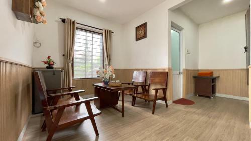 a living room with a table and chairs and a window at Homestay MINH TÚ in Hue