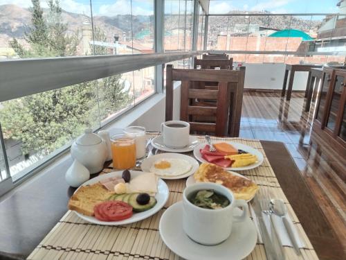 einen Frühstückstisch mit Frühstückszutaten und Kaffee darauf in der Unterkunft Dreams Boutique Hotel Cusco in Cusco