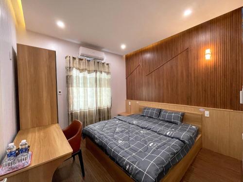 1 dormitorio con 1 cama y pared de madera en Homestay T&T - Căn hộ gia đình, en Da Nang