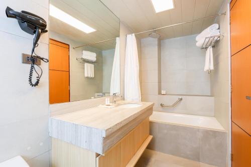 a bathroom with a sink and a bath tub at Sotogrande Hotel Baguio in Baguio