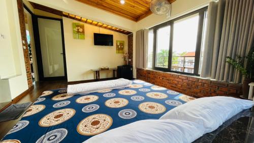 ein großes Bett in einem Zimmer mit einem großen Fenster in der Unterkunft Homestay MINH TÚ in Hue