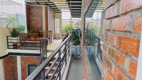 a balcony with tables and chairs and a brick wall at Homestay MINH TÚ in Hue