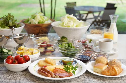 a table with plates of food and bowls of food at 北軽井沢　Golden Forest Hotel in Naganohara