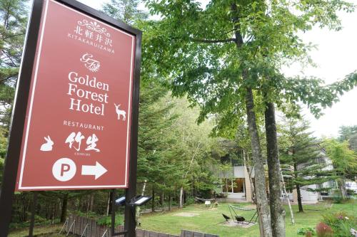 un panneau indiquant l'hôtel de la forêt dorée dans l'établissement 北軽井沢　Golden Forest Hotel, à Naganohara