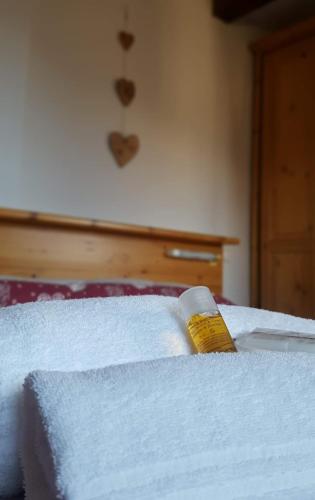 a bottle of honey sitting on top of a bed at Hotel Martin in Sauze dʼOulx